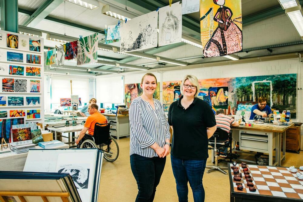 Zwei Frauen im Atelier PIX stehen im Raum vor vielen Gemälden